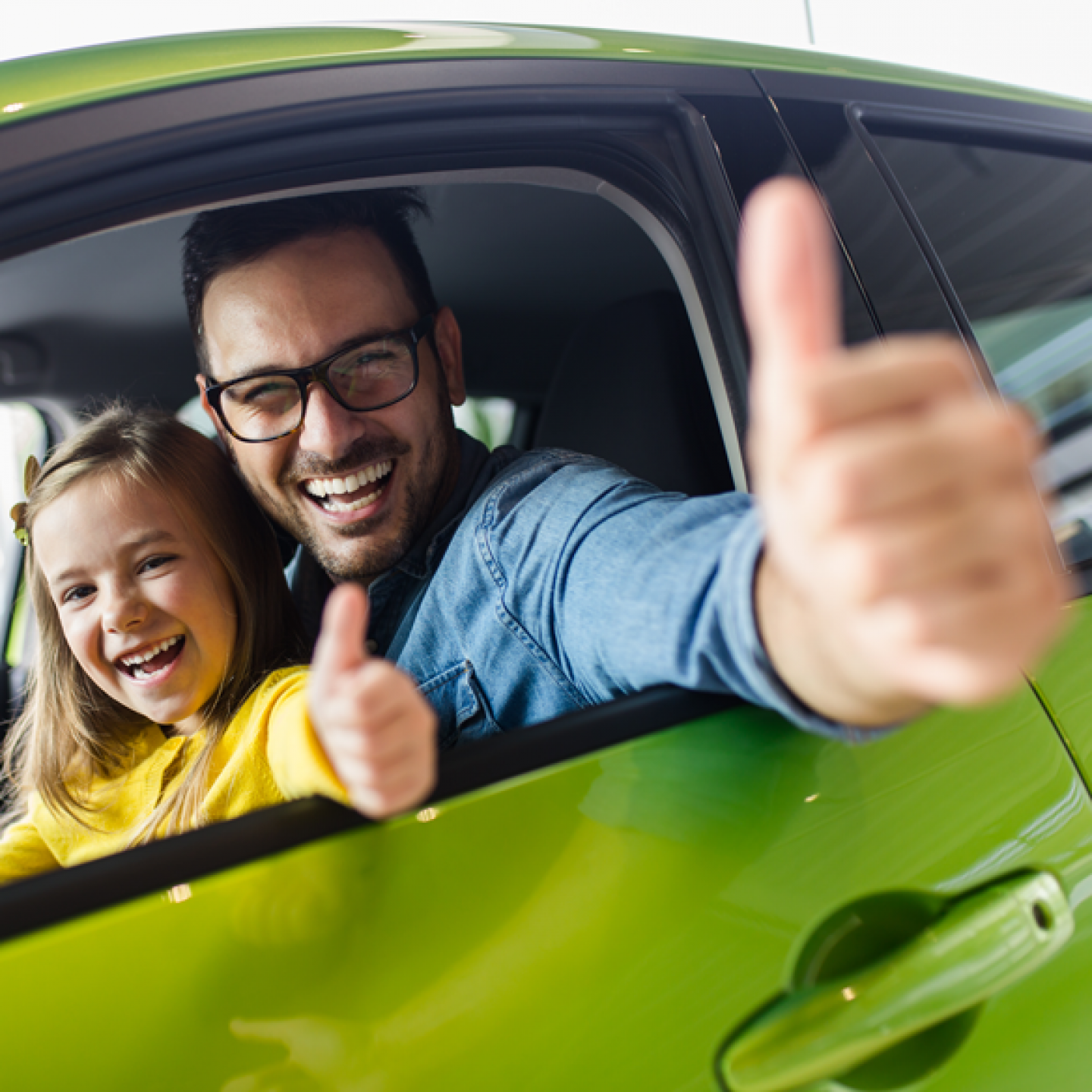 Father and daughter in car in North East England with thumbe up